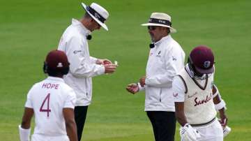 Umpires Michael Gough and Richard Illingworth sanitise the ball after saliva is accidentally added to it during Day Four of the 2nd Test Match in the #RaiseTheBat Series between England and The West Indies at Emirates Old Trafford on July 19