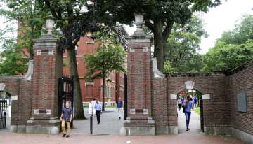 FILE - In this Aug. 13, 2019, file photo, pedestrians walk through the gates of Harvard Yard at Harvard University in Cambridge, Mass. Harvard and the Massachusetts Institute of Technology filed a federal lawsuit Wednesday, July 8, 2020, challenging the Trump administration's decision to bar international students from staying in the U.S. if they take classes entirely online this fall. Some institutions, including Harvard, have announced that all instruction will be offered remotely in the fall during the ongoing coronavirus pandemic. (AP Photo/Charles Krupa, File)