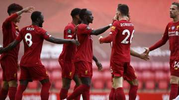 Liverpool's Sadio Mane, center, celebrates after scoring the opening goal during the English Premier League soccer match between Liverpool and Aston Villa at Anfield Stadium in Liverpool, England, Sunday, July 5