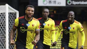 Watford's Troy Deeney, left, celebrates with teammates after scores his side's second goal from the penalty spot during the English Premier League soccer match between Watford and Newcastle at the Vicarage Road Stadium in Watford