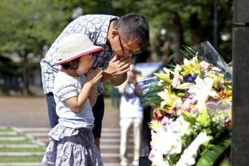  A man and his daughter pray for the victims of U.S. atomic bombing at the Atomic Bomb Hypocenter Pa