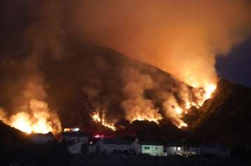The Ranch Fire burns over a residential area, Thursday, Aug. 13, 2020, in Azusa, Calif. Heat wave co