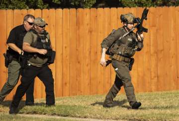 Police officers work near the house in Cedar Park, Texas, where a person remained barricaded Sunday,