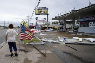 Dustin Amos walks near debris at a gas station on Thursday, Aug. 27, 2020, in Lake Charles, La., aft