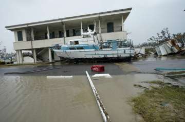 Flooding surrounds a damaged building and boat Friday, Aug. 28, 2020, in Cameron, La., after Hurrica