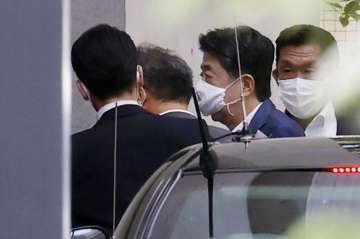 Japanese Prime Minister Shinzo Abe, center right, arrives at Keio University Hospital in Tokyo Monda
