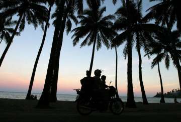 A motorist drives along the sea shore with his family in Port Blair, in India's Andaman and Nicobar 