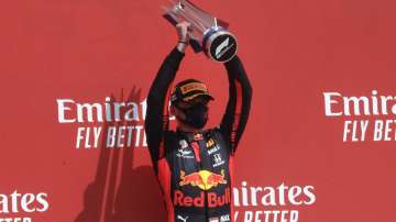 Red Bull driver Max Verstappen of the Netherlands holds up the trophy on the podium after taking first place in the 70th Anniversary Formula One Grand Prix at the Silverstone circuit, Silverstone, England, Sunday, Aug. 9