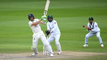 Jos Buttler of England hits out watched on by Mohammad Rizwan of Pakistan during Day Four of the 1st #RaiseTheBat Test Match between England and Pakistan at Emirates Old Trafford on August 08