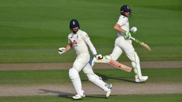 Chris Woakes and Jos Buttler of England run during Day Four of the 1st #RaiseTheBat Test Match between England and Pakistan at Emirates Old Trafford on August 08