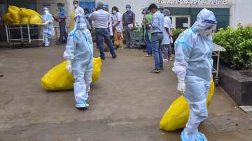 Health workers carry medical waste for disposal at Calcutta Medical College Hospital, during the biw