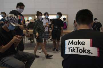 A visitor to an Apple store wears a t-shirt promoting Tik Tok in Beijing on Friday, July 17, 2020. U.S. President Donald Trump on Thursday, Aug 6, 2020 ordered a sweeping but unspecified ban on dealings with the Chinese owners of consumer apps TikTok and WeChat, although it remains unclear if he has the legal authority to actually ban the apps from the U.S. 