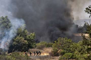 Los Angeles Fire Department firefighters hike into the Sepulveda Basin to fight a brush fire in the 