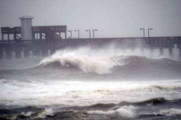 Waves crash near a pier, at Gulf State Park, Tuesday, Sept. 15, 2020, in Gulf Shores, Ala. Hurricane