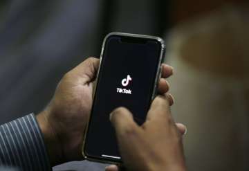 FILE - In this July 21, 2020 file photo, a man opens social media app 'TikTok' on his cell phone, in