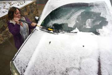 Diane Lee cleans the windshield of her sports-utility vehicle as she heads home after a day at her job with the Clear Creek County Sheriff's Department while a storm packing high winds and snow sweeps through the intermountain West Tuesday, Sept. 8, 2020, in Georgetown, Colo. Forecasters predict that the storm will continue through Wednesday before moving out on to the plains.