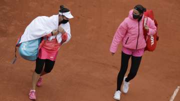 Victoria Azarenka of Belarus, right, and Montenegro's Danka Kovinic walk onto the court to resume the first round match of the French Open tennis tournament against at the Roland Garros stadium in Paris, France, Sunday, Sept. 27