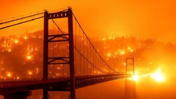 In this image taken with a slow shutter speed, embers light up a hillside behind the Bidwell Bar Bridge as the Bear Fire burns in Oroville, California, on Wednesday, September 9, 2020. The blaze, part of the lightning-sparked North Complex, expanded at a critical rate of spread as winds buffeted the region.
