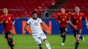 Germany's Ilkay Gundogan, center, runs with the ball past Spain's Thiago Alcantara, left, and Spain's Fabian Ruiz during their UEFA Nations League soccer match at the Mercedes-Benz Arena stadium in Stuttgart, Germany, Thursday, Sept. 3