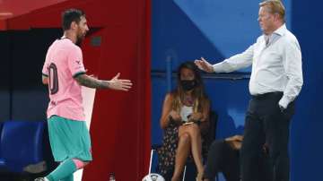Barcelona's Lionel Messi, left, shakes hands as he is substituted with Barcelona's coach Ronald Koeman as he is substituted during the pre-season friendly soccer match between Barcelona and Girona at the Johan Cruyff Stadium in Barcelona, Spain, Wednesday, Sept. 16