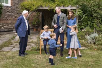 Britain's Prince William, centre, and Kate, the Duchess of Cambridge, react with Naturalist David At