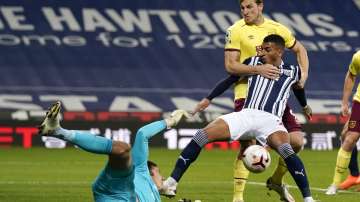 Burnley's goalkeeper Nick Pope, left, and Chris Wood top, attempts to take the ball away from West Brom's Karlan Grant during the English Premier League soccer match between West Bromwich Albion and Burnley at the Hawthorns in West Bromwich, England, Monday Oct. 19