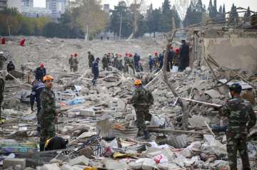 Soldiers and firefighters search for survivors in a residential area that was hit by rocket fire ove