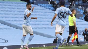 Manchester City's Riyad Mahrez, left celebrates with teammate Manchester City's Eric Garcia after scoring the opening goal of the game during the English Premier League soccer match between Manchester City and Leicester City at the Etihad stadium in Manchester, England, Sunday, Sept. 27