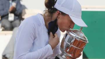 Poland's Iga Swiatek kisses the trophy after winning the final match of the French Open tennis tournament against Sofia Kenin of the U.S. in two sets 6-4, 6-1, at the Roland Garros stadium in Paris, France, Saturday, Oct. 10