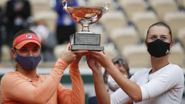 Hungary's Timea Babos,left, France's Kristina Mladenovic hold the trophy after winning the women's doubles final match of the French Open tennis tournament against Chile's Alexa Guarachi and Desirae Krawczyk of the U.S. at the Roland Garros stadium in Paris, France, Sunday, Oct. 11