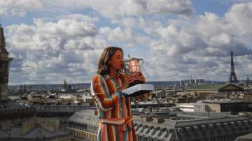 Poland's Iga Swiatek, suddenly becoming a Grand Slam champion at the age of 19, poses with her trophy during a photo call on the rooftop of Galeries Lafayette, Sunday, Oct. 11