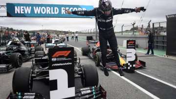 Mercedes driver Lewis Hamilton of Britain jumps out of his car after his record breaking 92nd win at the Formula One Portuguese Grand Prix at the Algarve International Circuit in Portimao, Portugal, Sunday, Oct. 25