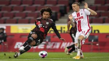 Bavaria's Joshua Zirkzee, left, stumbles next to Cologne's Marius Wolf during the German Bundesliga soccer match between 1. FC Cologne and Bayern Munich in Cologne, Germany, Saturday, Oct. 31