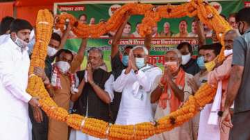 Bihar CM Nitish Kumar with Deputy CM Sushil Kumar Modi garlanded by party supporters during an election meeting on Sunday.