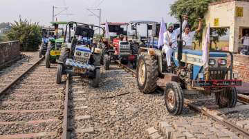 Farmers raise slogans as they block train tracks with tractors on the twentieth day of their ongoing Rail Roko protest over recent farm reform bills, at Devi Dass Pura village in Amritsar.?