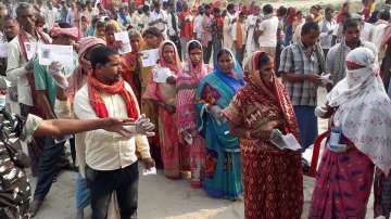 Voters stand in queues to cast their votes during the second phase of Bihar assembly elections in Patna.