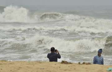 Chennai: A man clicks photographs as turbulent waves crash the shore before the landfall of Cyclone Nivar, at Marina Beach in Chennai, Tuesday, Nov. 24, 2020.