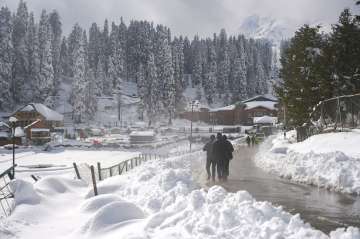 Gulmarg: People walk on a road after the seasons first snowfall at Gulmarg of Baramulla District of North Kashmir, Monday, Nov. 16, 2020. Authorities in the Valley issued an avalanche warning in four districts of the valley as the higher reaches of the union territory received moderate to heavy snowfall, while the plains were lashed by rains. 