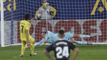 Villareal's Gerard Moreno, left, scores the penalty kick past Real Madrid's goalkeeper Thibaut Courtois as Real Madrid's Mariano Diaz looks on during the Spanish La Liga soccer match between Villarreal and Real Madrid in Ceramica stadium in Villarreal, Spain, Saturday Nov. 21
