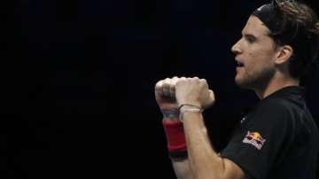 Dominic Thiem of Austria celebrates after winning his semifinal match against Novak Djokovic of Serbia at the ATP World Finals tennis tournament at the O2 arena in London, Saturday, Nov. 21