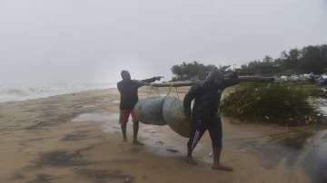 Fishermen move towards a safer place from a coastal area, as Cyclone Nivar is expected to make landf