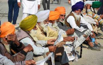 New Delhi: Farmers read newspapers at Singhu border during their ongoing protest march Delhi Chalo against Centres new farm laws, in New Delhi, Sunday, Nov. 29, 2020.