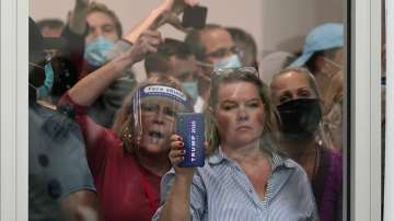 People wanting to be election challengers yell as they look through the windows of the central counting board as police were helping to keep additional challengers from entering due to overcrowding.