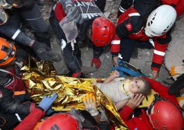 Rescue workers, who were trying to reach survivors in the rubble of a collapsed building, surround A