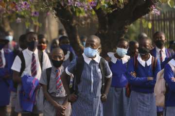 Schoolchildren wait to enter their school in Harare, Zimbabwe