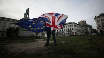 A man unfurls a Union and EU flag outside the European Parliament in Brussels. 