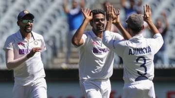 India's Ravichandran Ashwin, centre, celebrates with teammate Ajinkya Rahane, right, after dismissing Australia's Tim Paine during play on day one of the Boxing Day cricket test between India and Australia at the Melbourne Cricket Ground, Melbourne, Australia, Saturday, Dec. 26