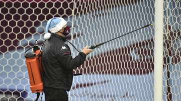 The goal post is sprayed with disinfectant before the English Premier League soccer match between Aston Villa and Crystal Palace at the Villa Park stadium in Birmingham, England, Saturday, Dec. 26