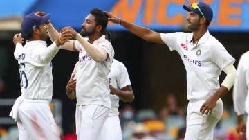India's Mohammed Siraj, centre, celebrates with teammate Mayank Agarwal, left, after taking his fifth wicket during play on day four of the fourth cricket test between India and Australia at the Gabba, Brisbane, Australia, Monday, Jan. 18