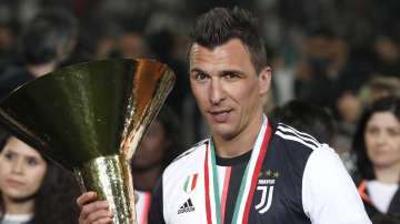 In this May 19, 2019 file photo, Juventus' Mario Mandzukic holds the Serie A soccer title trophy, at the Allianz Stadium in Turin, Italy. 